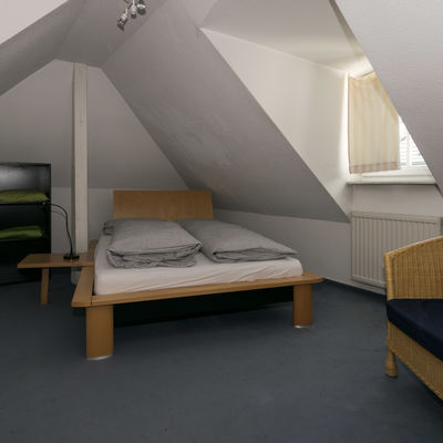 Zimmer mit Doppelbett im Dachgeschoss.