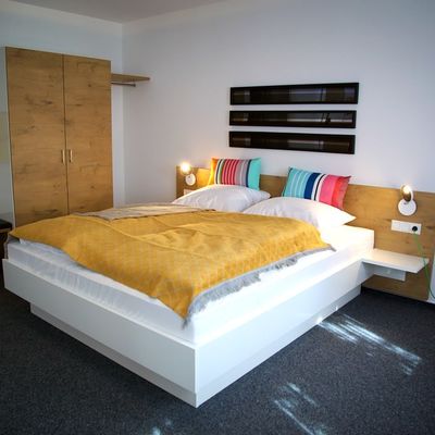 Modern eingerichtetes Zimmer mit Doppelbett.