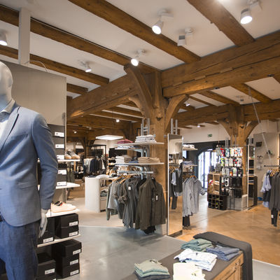 Chic fashion store from the inside, with beams on the ceiling and wooden support beams.