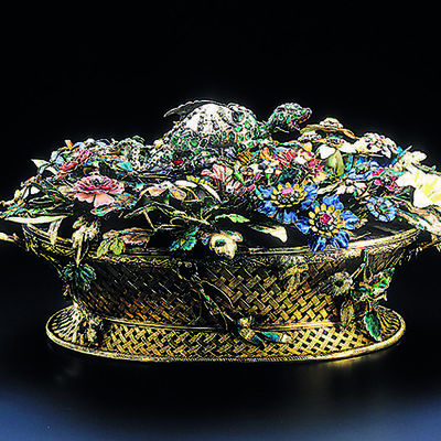 A golden, Filifgran basket filled with various, finely crafted, colorful flowers and blossoms, partly set with precious stones.