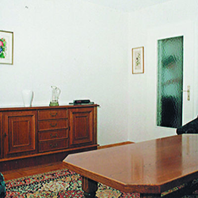Rustikalers Wohnzimmer mit Sofa, Tisch und Kommode.