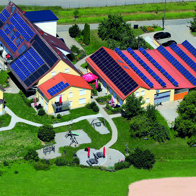 Luftbild eines großen Hofes, besehtend aus mehreren Gebäuden und Grünfläche außen herum.