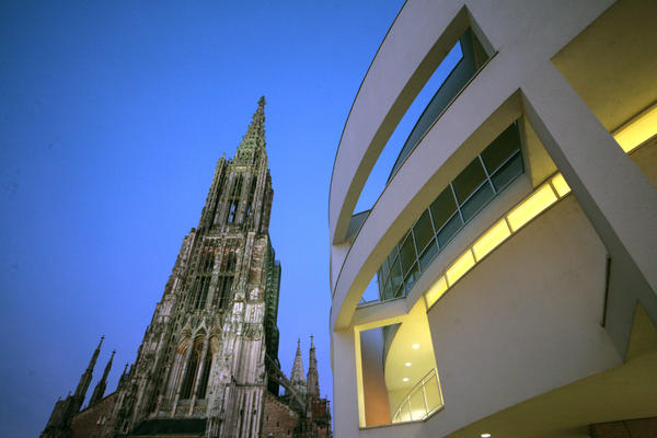 Das Ulmer Münster und ein Teil des Stadthauses sind bei Dämmerung aus der Forschperspektive abgelichtet.
