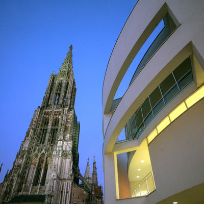 Das Ulmer Münster und ein Teil des Stadthauses sind bei Dämmerung aus der Forschperspektive abgelichtet.