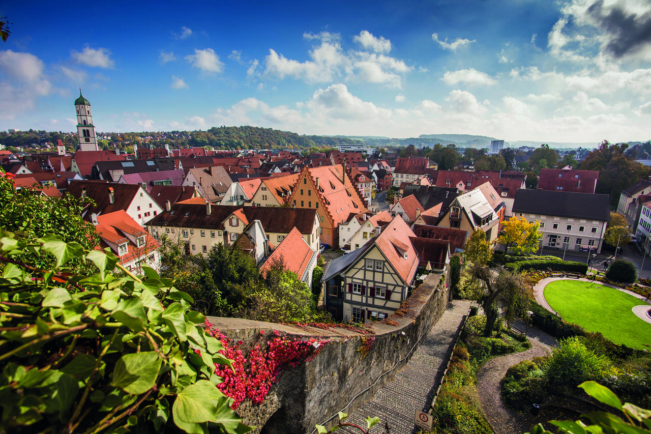 Herbstlicher Panoramablick auf die historische Altstadt von Biberach bei strahlend blauem Himmel: Eine Treppe führt entlang der Stadtmauer hinunter zu den Fachwerkhäusern von Biberach.